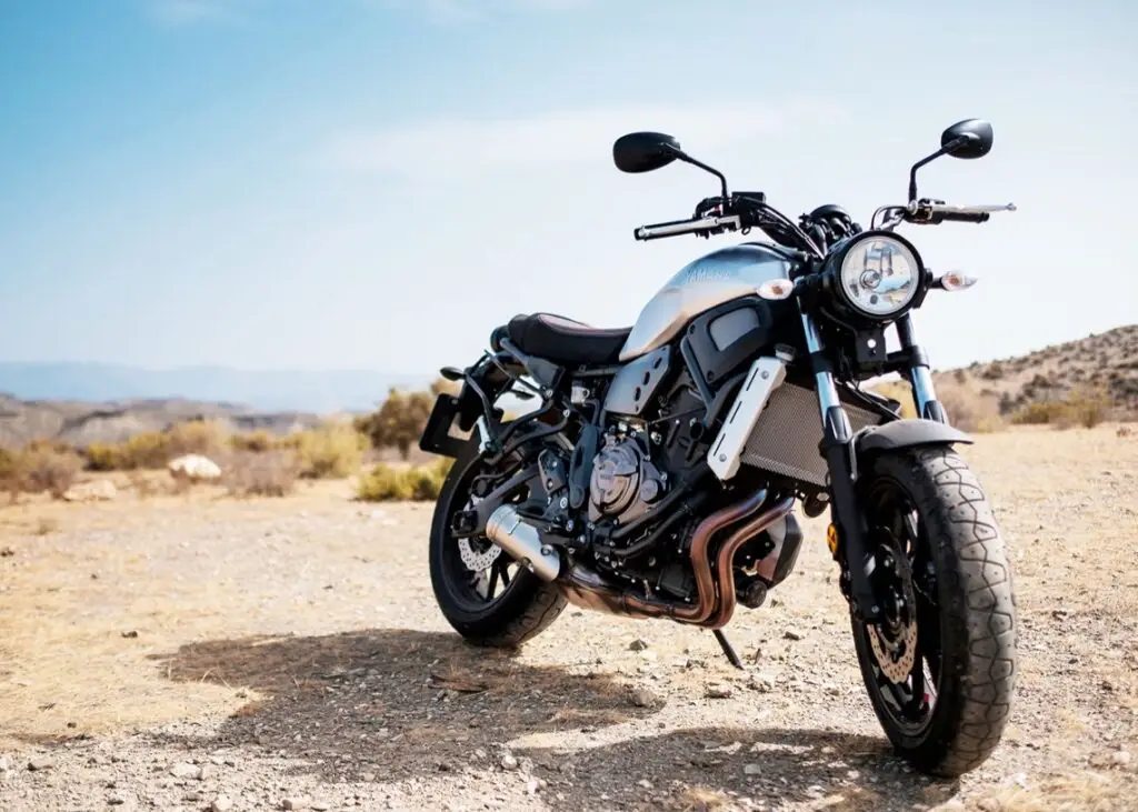 A Yamaha scrambler motorcycle parked in a desert landscape